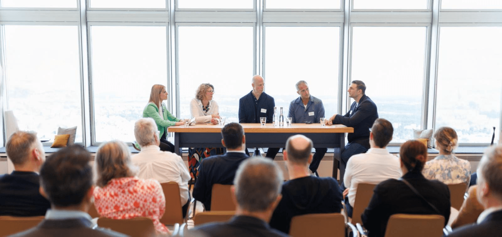 Paneldiskussion mit mehreren Referierenden vor Publikum in einem Unternehmens-Event